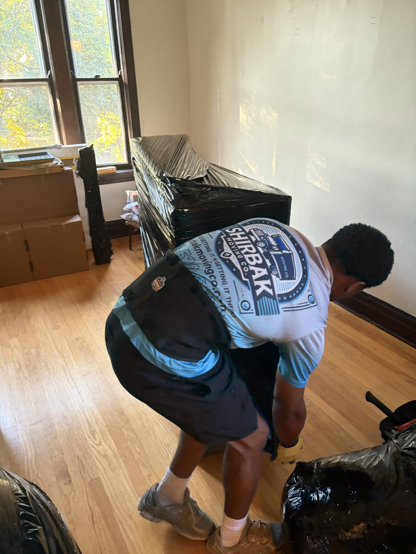 A ShirBak crew member carrying protected furniture through a home.
