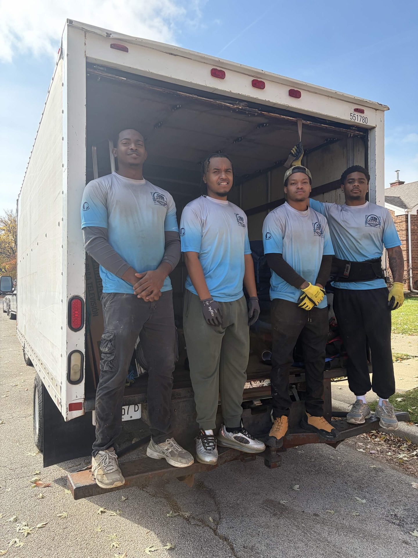 ShirBak crew at the open liftgate of their moving truck.